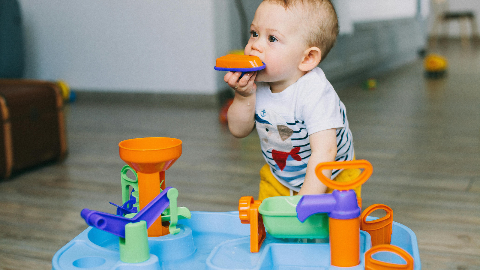A parent completes medical history forms while their baby explores a toy from the office's collection.